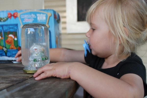 A child looking at a DIY snow globe